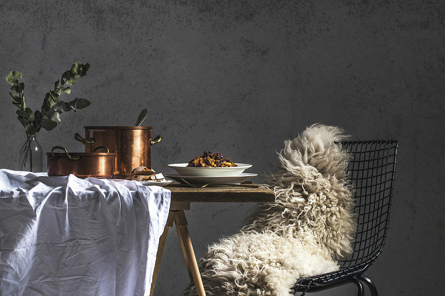A Wire Chair With A Sheepskin Rug With Copper Pots And Winter Dishes Photograph by Karolina Kosowicz