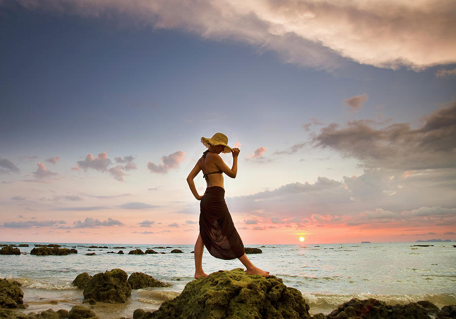 A Woman Wearing A Hat And Sarong Stands Photograph by Sean White / Design Pics
