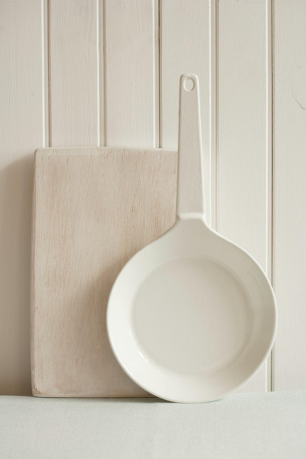 A Wooden Chopping Board And A Pan Leaning Against A Light Wooden Wall Photograph by Colin Cooke