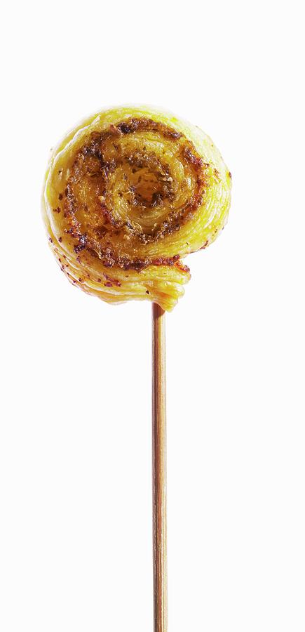 A Wooden Skewer Topped With A Puff Pastry Whirl With Pesto Photograph by Atelier Mai 98