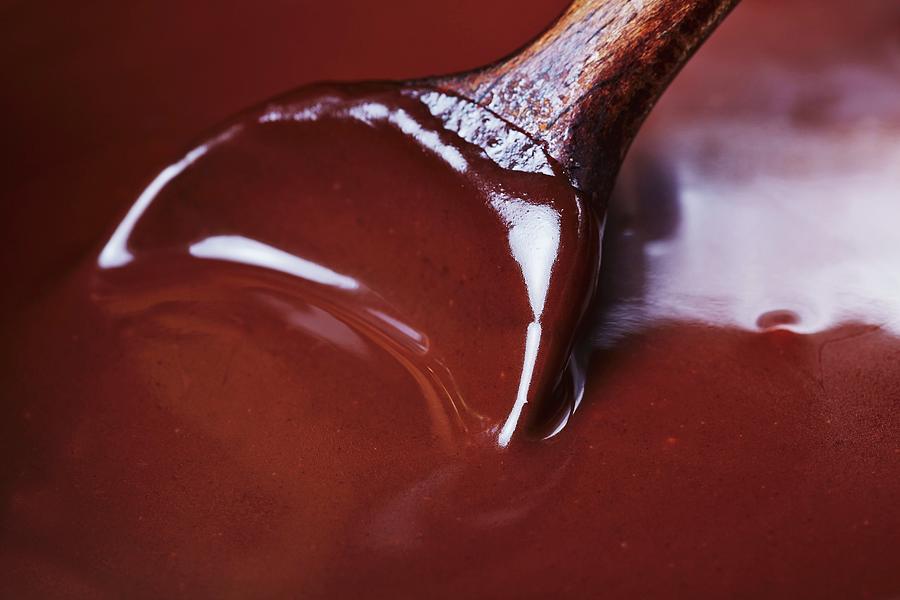 A Wooden Spoon Stirring Melted Dark Chocolates Photograph by Robert Kneschke