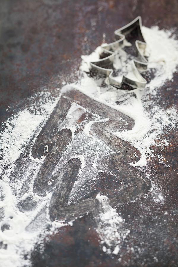 A Worktop With A Christmas Tree Outlined In The Flour And A Christmas Tree-shaped Cutter Photograph by Eising Studio - Food Photo & Video