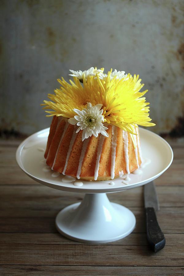 A Yellow Cake With Flowers On A Cake Stand Photograph by Milly Kay