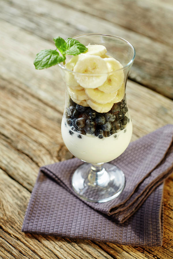 A Yoghurt Dessert With Blueberries, Banana And Mint Photograph by Niklas Thiemann