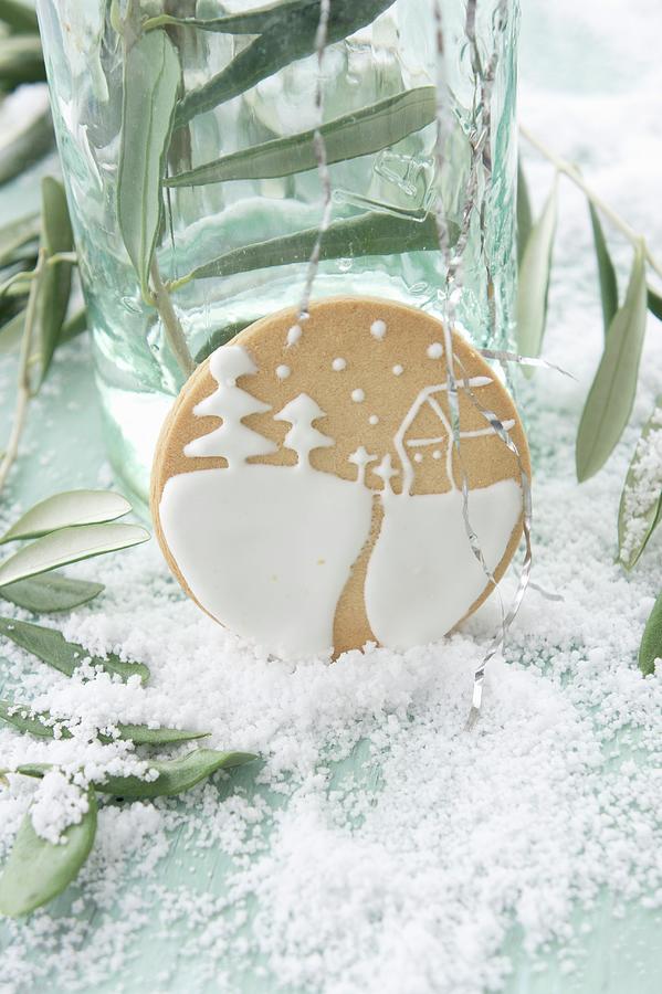 About Biscuits Iced With A Winter Landscape Between Olive Sprigs On A Table Covered With Snow Photograph by Martina Schindler