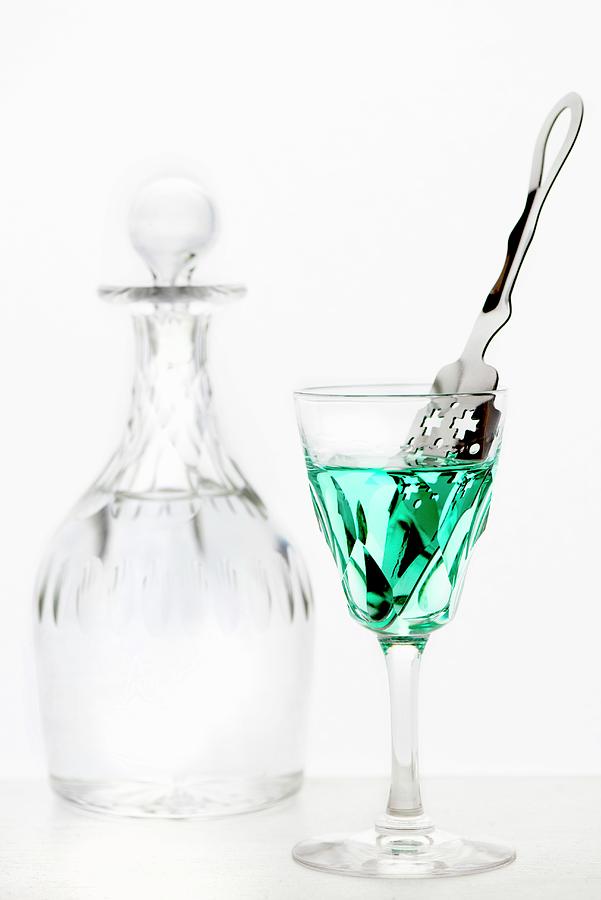 Absinthe With An Absinthe Spoon In A Crystal Glass In Front Of A Crystal Carafe Of Water Photograph by Jamie Watson