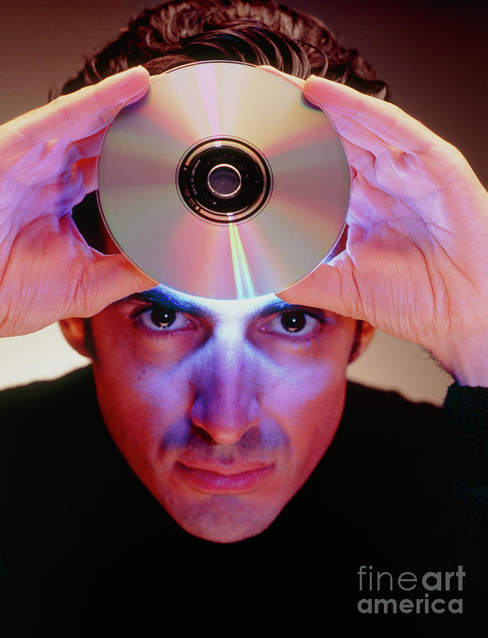 Abstract Image Of Man Holding Up A Cd-rom Disk Photograph by Oscar Burriel/science Photo Library