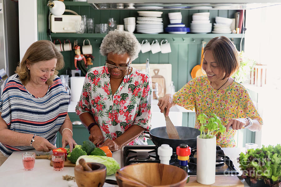 Active Senior Women Friends Cooking In Kitchen Photograph by Caia  Image/science Photo Library