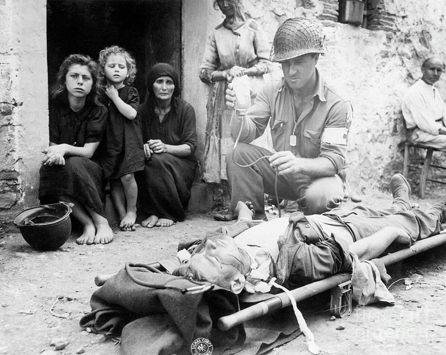 Administering Plasma To Wounded Soldier by Bettmann