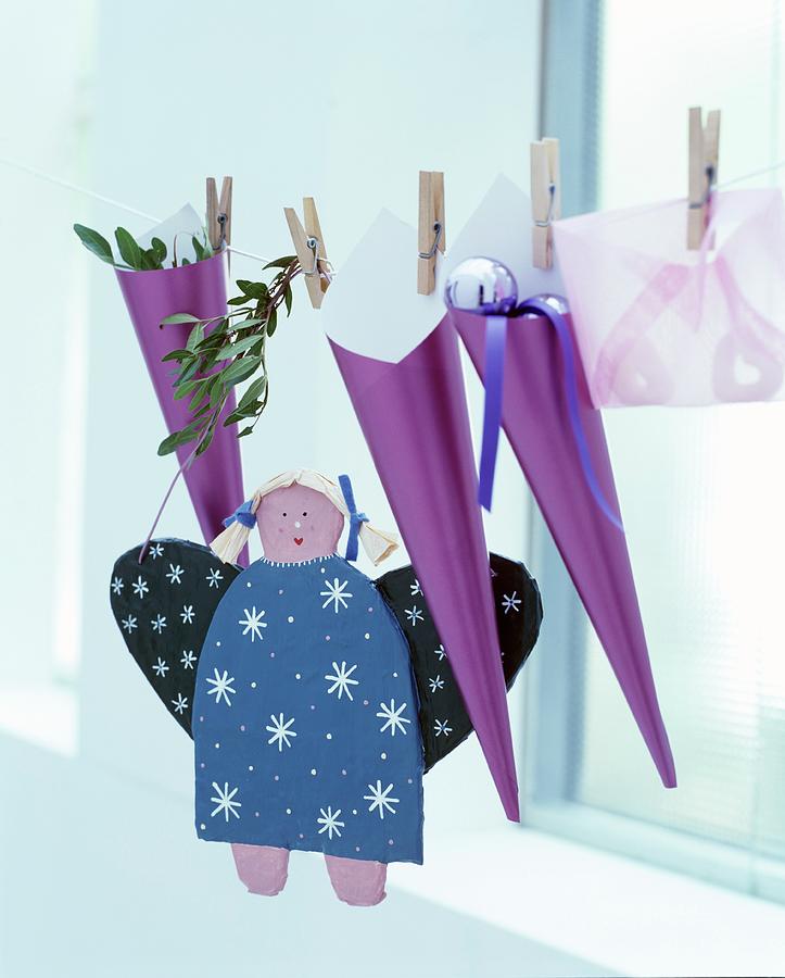 Advent Calendar Hand-made From Purple Cones Hung From Cord And Hand-made Angel Figurine Photograph by Matteo Manduzio