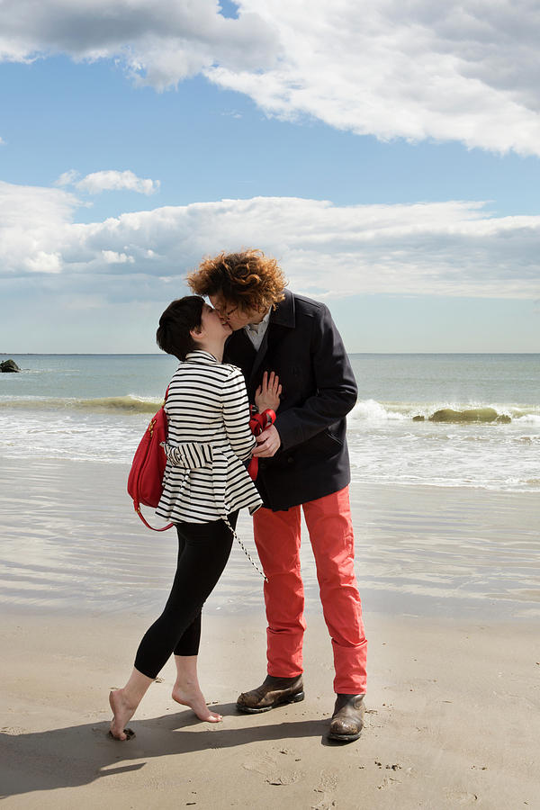 Affectionate Couple Kissing While Standing On Shore At Beach Photograph By Cavan Images Fine 8004