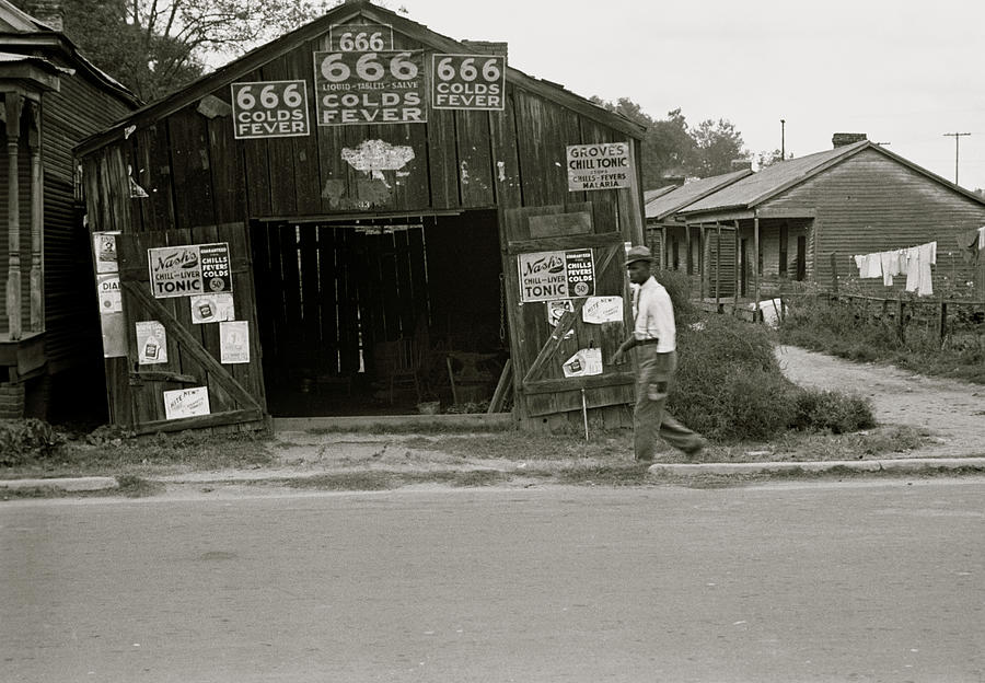 African American walks in front of, Advertisements for popular malaria ...