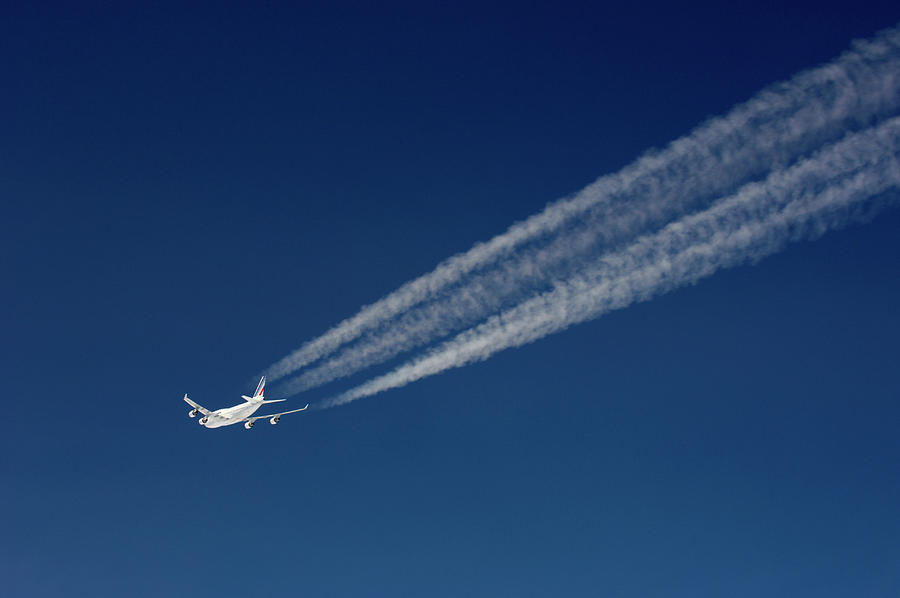 Aircraft With Contrails In Front Of A Dark Blue Sky Photograph by Josef Willems