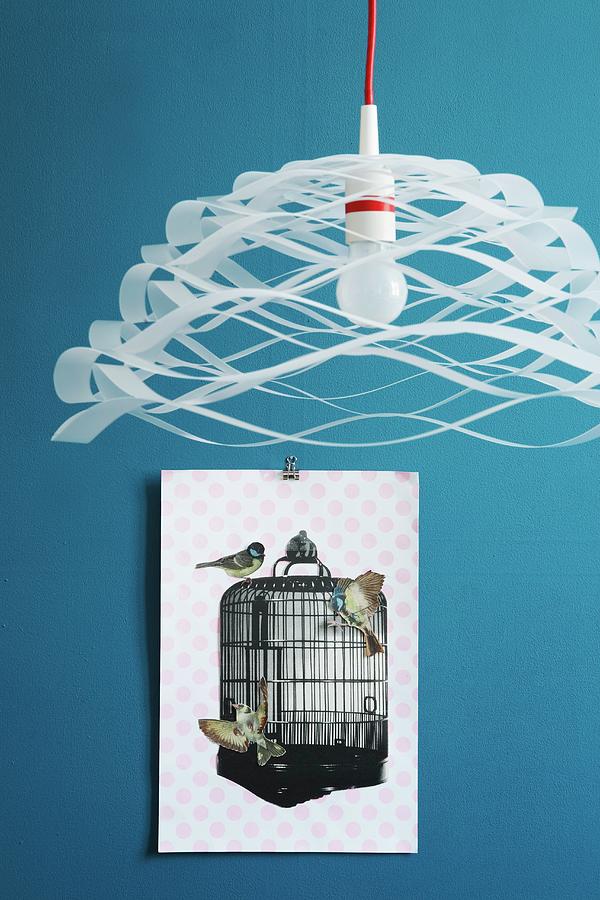 Airy, Paper Pendant Lamp In Front Of Collage Of Cut-out Paper Birds And Birdcage On Blue Wall Photograph by Alexandra Loock