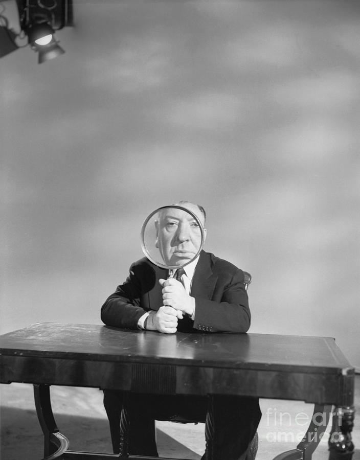 Alfred Hitchcock Holding Magnifying Photograph by Bettmann