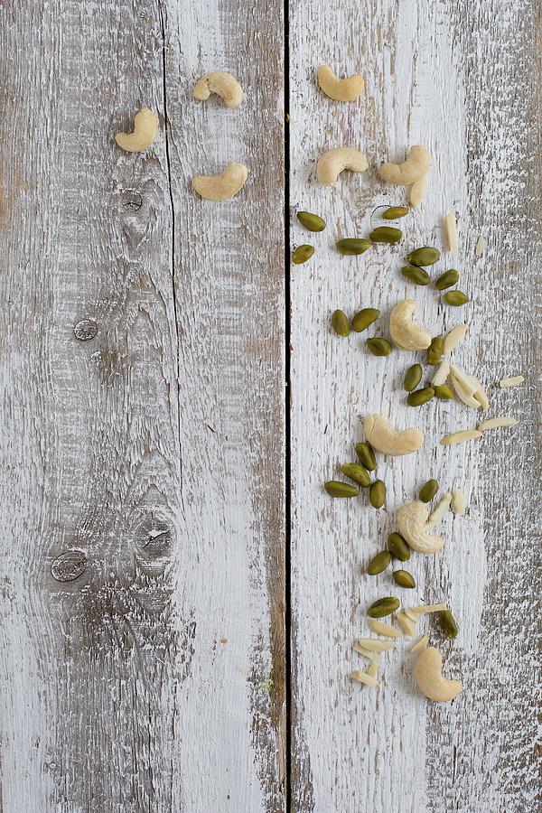 Almond Slivers, Cashews And Pistachios On A Wooden Background seen From Above Photograph by Tina Engel