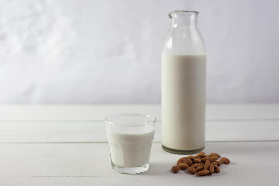 Almonds, And Almond Milk In A Glass And In A Bottle Photograph by Isolda Delgado Mora