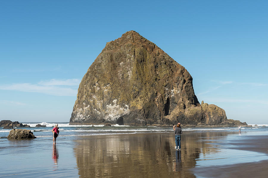 An Adult Couple Take A Photo With The Phone To A Young Couple Wicannon Beach, Oregon, Usa - October Photograph