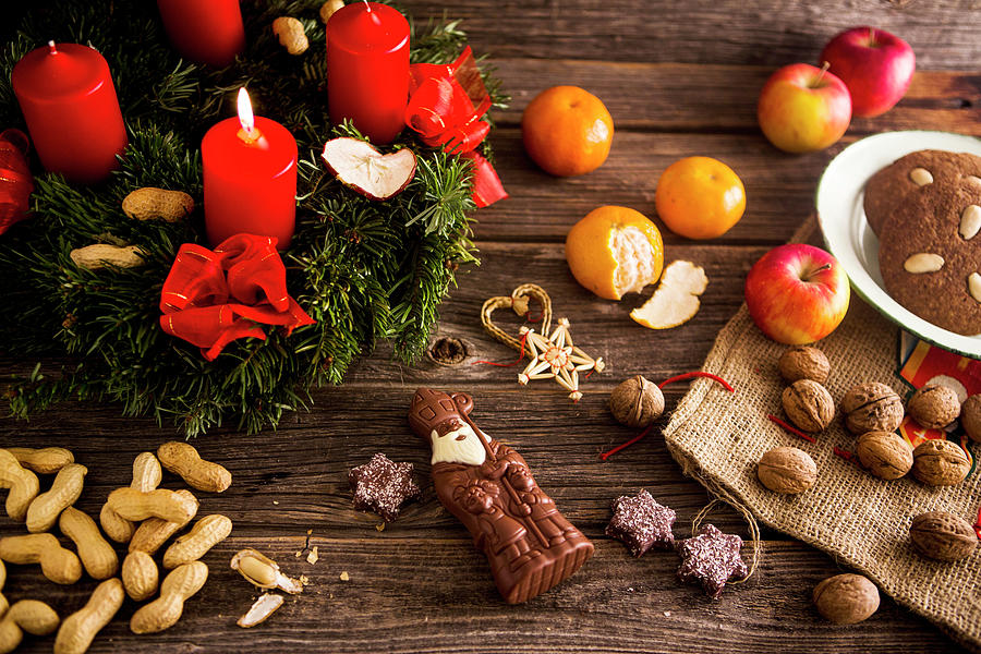 An Advent Wreath, A Chocolate Father Christmas, Nuts And Gingerbread Photograph by Sandra Krimshandl-tauscher