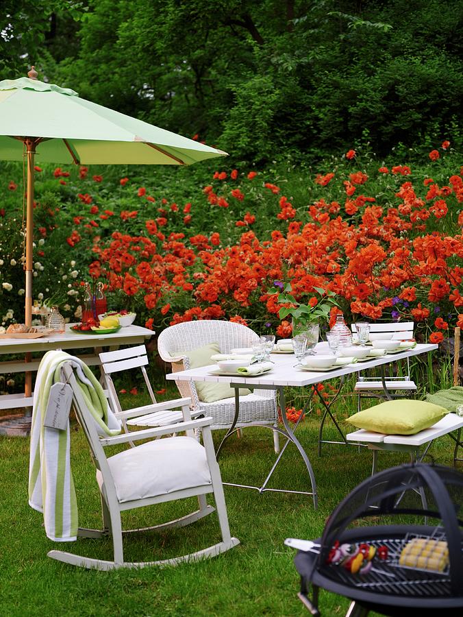 An Afternoon Barbeque In A Garden With A Red Flower Bed In The Background Photograph by Per Magnus Persson