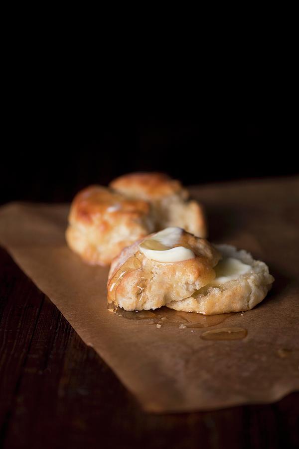An American Biscuit With Butter On A Piece Of Baking Paper Photograph by Rose Hodges