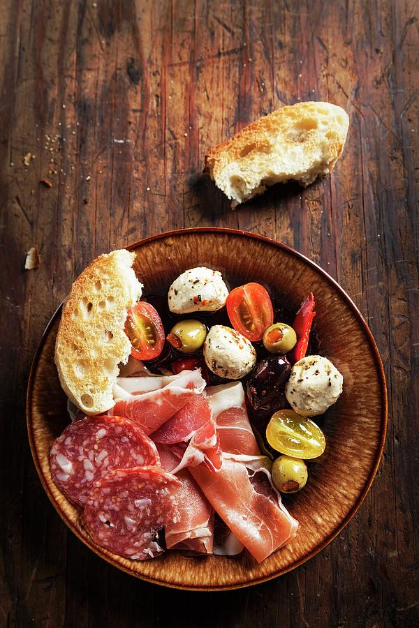 An Antipasti Platter Featuring Proscuitto, Mozzarella, Tomatoes, Olives, Salami And Bread italy Photograph by George Crudo