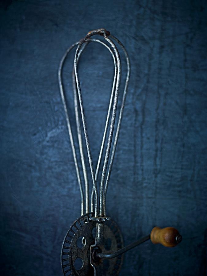 An Antique Whisk On A Blue Surface seen From Above Photograph by Myles New