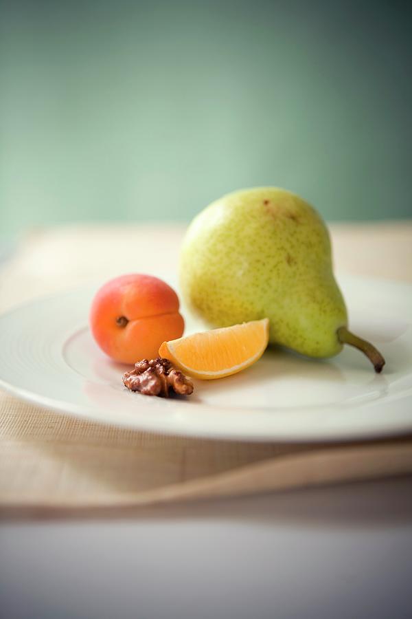 An Arrangement Featuring A Pear, An Apricot, An Orange Wedge And Half A Walnut Photograph by Rose Hodges