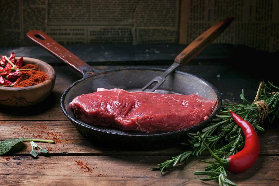 An Arrangement Featuring A Raw Beef Steak, Chillis And Herbs Photograph by Natasha Breen