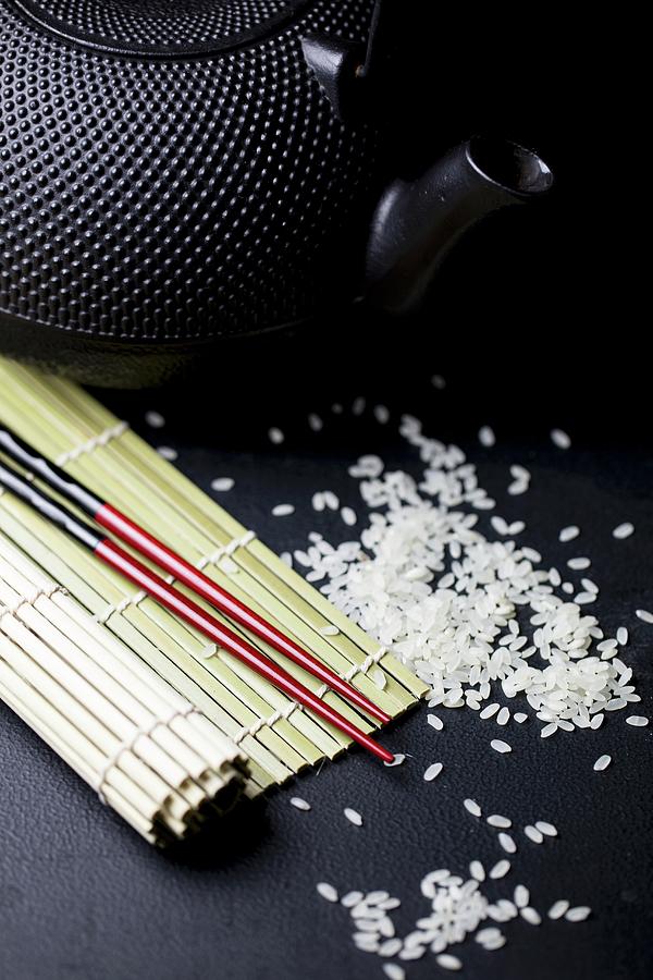 An Arrangement Featuring Chopsticks, A Bamboo Mat, A Teapot And Rice asia Photograph by Nicole Godt
