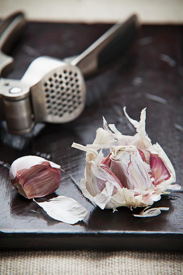 An Arrangement Featuring Garlic And A Garlic Press Photograph by Richard Church