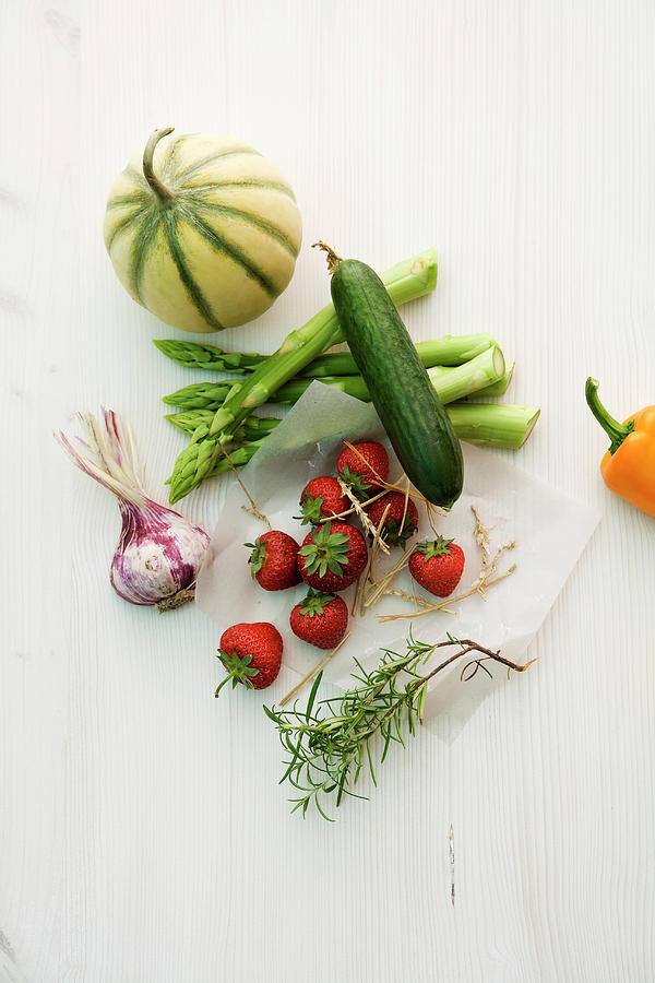 An Arrangement Of Asparagus, Cucumber, Garlic, Melon, Strawberries And Rosemary Photograph by Michael Wissing