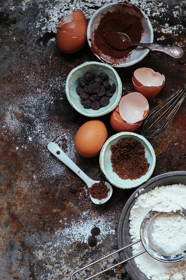 An Arrangement Of Baking Utensils: Cocoa, Chocolate Chips, Eggs, Flour And Sugar Photograph by Lucie Beck