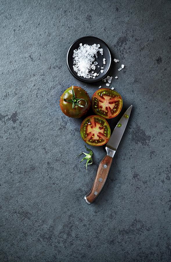 An Arrangement Of Black Tomatoes, Coarse Salt And A Kitchen Knife seen From Above Photograph by B.&.e.dudzinski