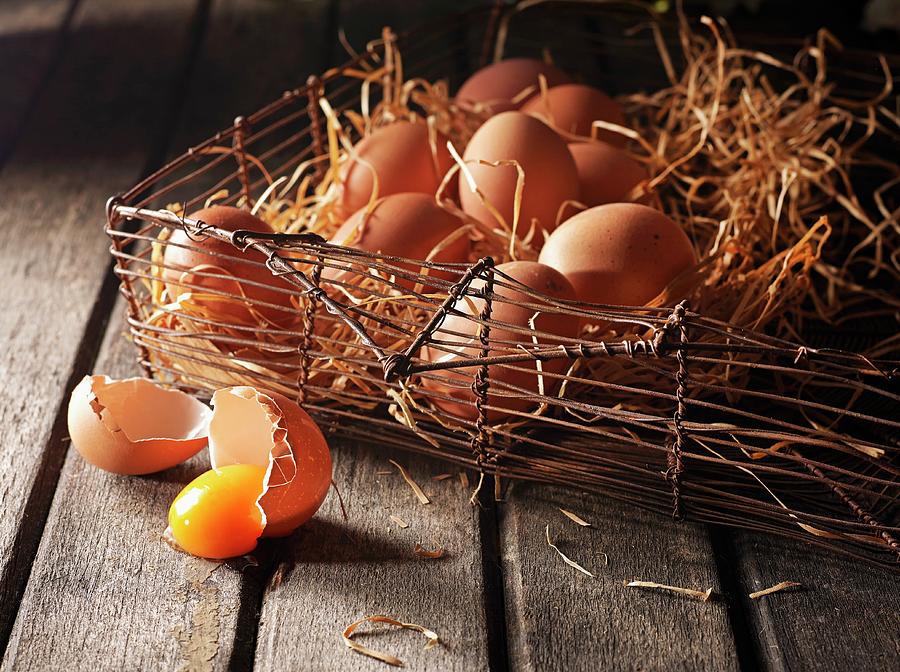 An Arrangement Of Brown Eggs In A Wire Basket With Wooden Shavings Photograph by Ludger Rose