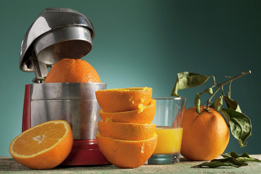 An Arrangement Of Fresh Orange Juice, An Orange Press And Squeezed Oranges Photograph by Blueberrystudio