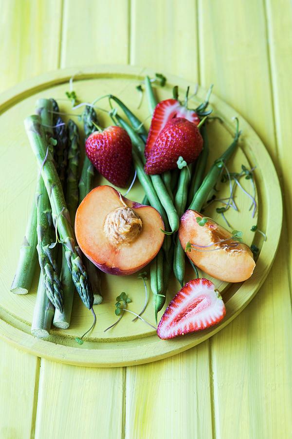 An Arrangement Of Green Asparagus And Green Beans, Strawberries And Peaches Photograph by Great Stock!