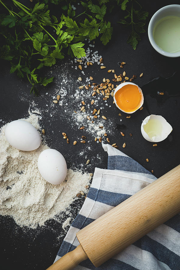 An Arrangement Of Ingredients And Utensils: Eggs, Flour, Herbs, Pine Nuts And A Rolling Pin Photograph by Karolina Kosowicz