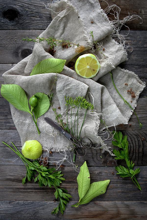 An Arrangement Of Lemons And Herbs On A Linen Cloth On A Wooden Table Photograph by Zaira Lavinia Zarotti