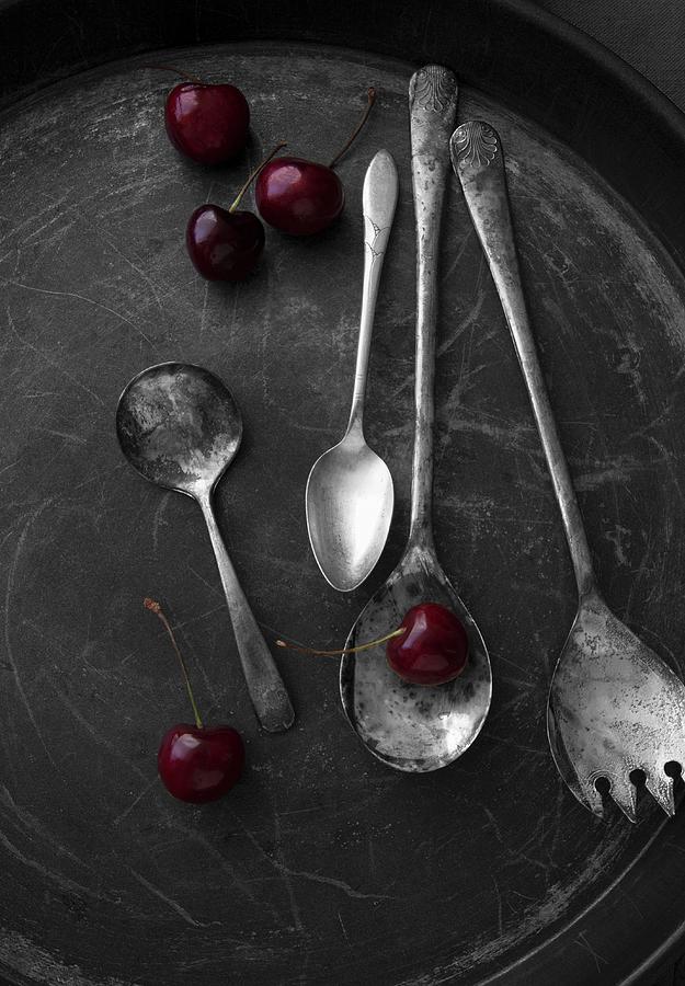 An Arrangement Of Old Silver Spoons And Bing Cherries Photograph by Katharine Pollak