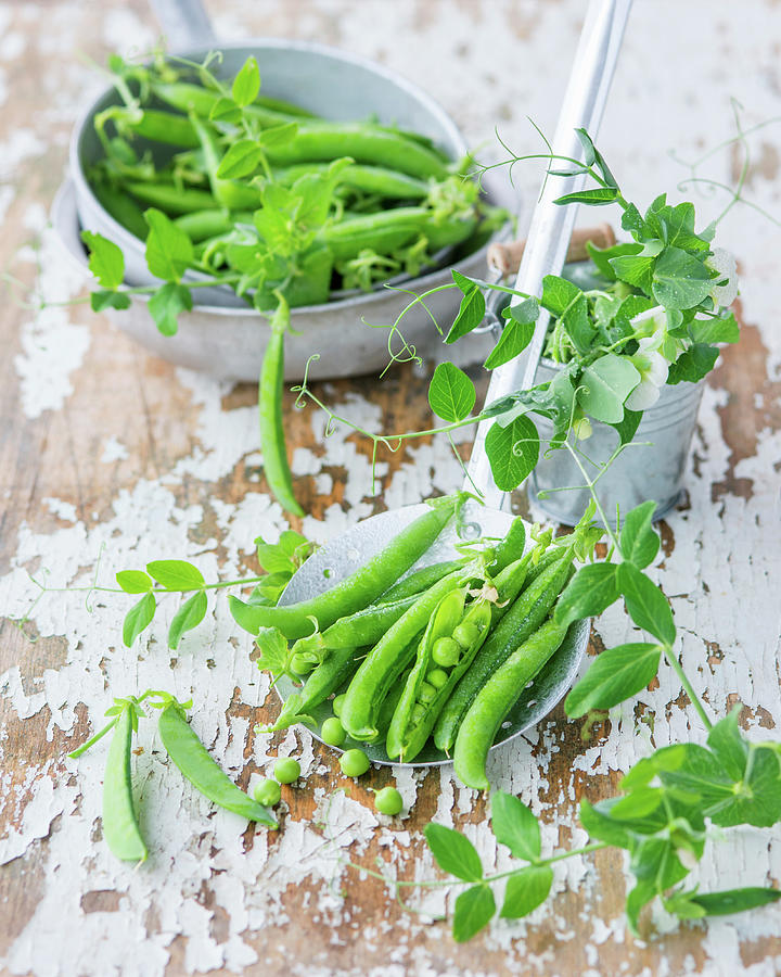 An Arrangement Of Peas With Flowers And A Draining Spoon Photograph by Irina Meliukh