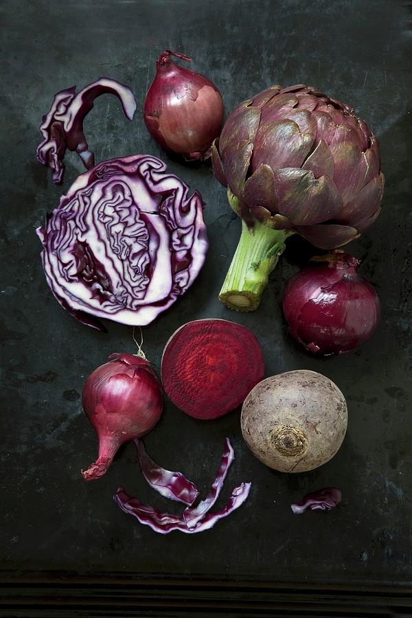 An Arrangement Of Vegetables Featuring Artichokes, Red Onions, Red Cabbage And Beetroot Photograph by Catja Vedder
