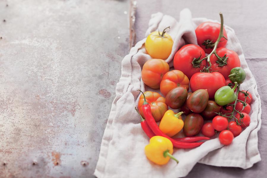 An Assortment Of Tomatoes And Chillies On A Cloth Photograph by Foodcollection