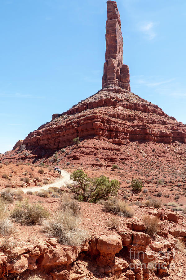 An ATV dune buggy passes Castle Butte on the dirt road leading t Photograph by William Kuta