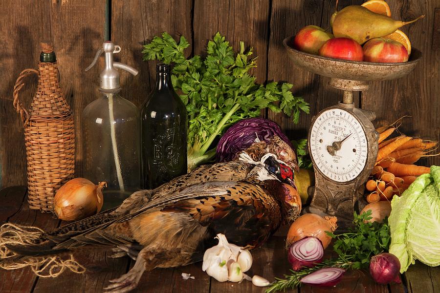 An Autumnal Arrangement Featuring Pheasant, Vegetables, Fruit, Nuts And An Old Pair Of Kitchen Scales Photograph by Monika Halmos