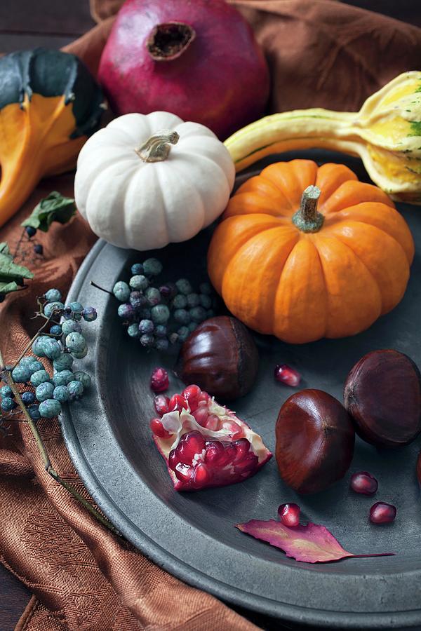 An Autumnal Arrangement Of Pumpkins, Chestnuts, Pomegranates And Berries Photograph by Katharine Pollak