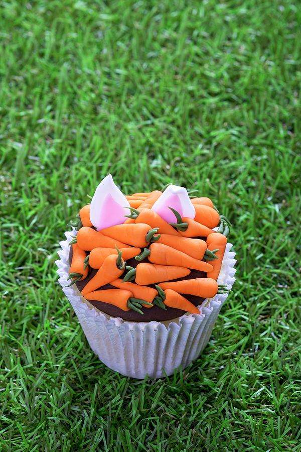 An Easter Cupcake Decorated With Carrots And Rabbit Ears Photograph by Adrian Britton