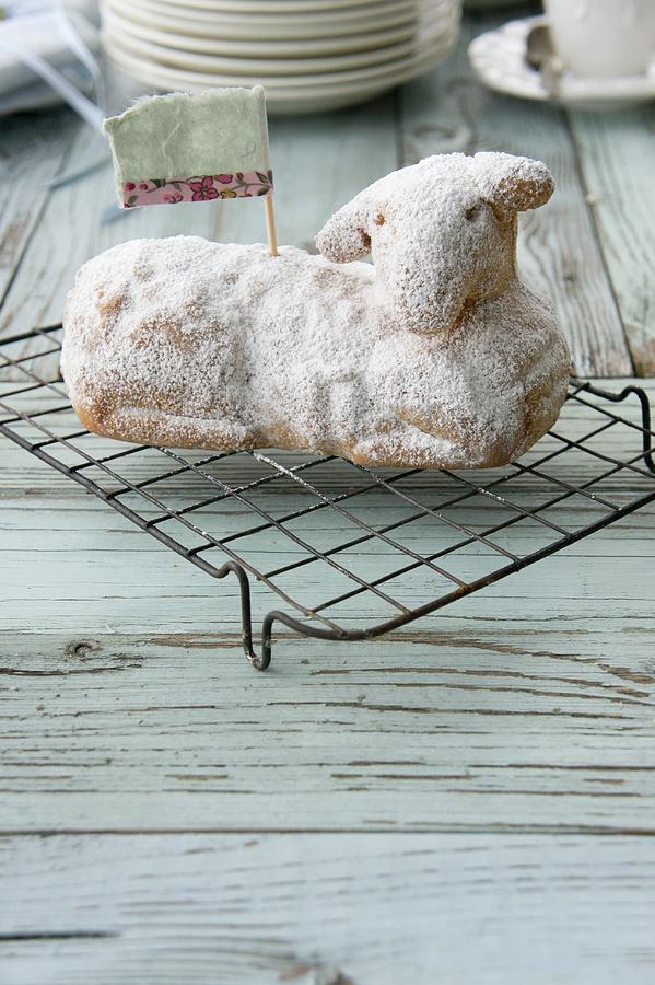 An Easter Lamb Cake Dusted With Icing Sugar On A Wire Rack Photograph