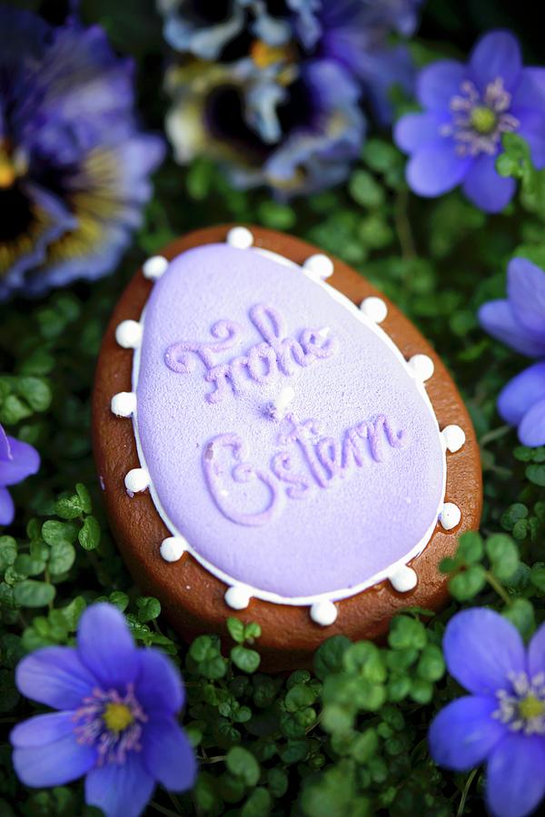 An Egg-shaped Candle With The Words frohe Ostern Surrounded By Liverwort Floweers Photograph by Angelica Linnhoff