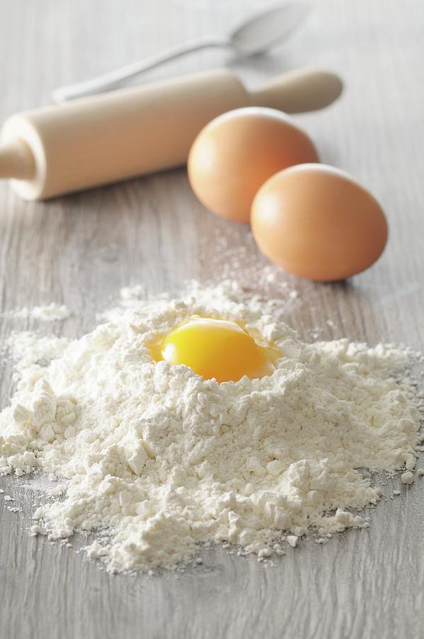 An Egg Yolk In A Pile Of Flour With Whole Eggs And A Rolling Pin Photograph by Jean-christophe Riou